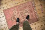 Soft pink tones, prayer motif, and worn texture of a distressed vintage Daulatabad rug.