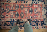 Distressed Melas rug close-up: worn pile, abrash, navy and cherry geometric patterns.