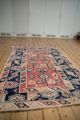 Distressed vintage Melas rug fringe and border with navy, cherry hook and latch motifs.