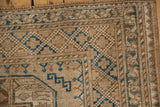 Distressed corner of vintage Ersari carpet with sand and dusty blue geometric-floral border.