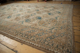 Distressed Ersari carpet with geometric guls and checkered multi-borders in sand, blue, brown.