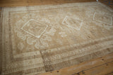 Distressed vintage Oushak rug with neutral abrashes, showing geometric medallion and reciprocating pawn border.