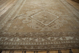 Distressed Oushak rug: reciprocating pawn border motif and faded neutral pile.