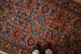 Dusty raspberry field of a vintage Lilihan rug with sapphire blue and aubergine gul motifs.