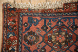 Vintage Persian Lilihan rug corner with dusty raspberry field, sapphire blue stylized vinery, and ivory fringe.