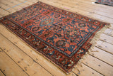 Vintage Lilihan rug corner, with tattered natural fringe and dusty raspberry field, sapphire blue motifs.