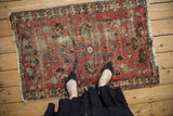 Persian Lilihan rug, faded raspberry allover floral design with extensive wear.