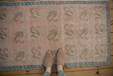 Overhead view of the distressed texture and large-scale floral pattern on a vintage Turkish Oushak rug.