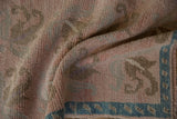 Even wear on the hand-knotted pile of a distressed Oushak rug with a turquoise border.
