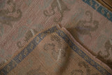 Reverse side of a distressed Oushak rug showing the hand-knotted weave and foundation.
