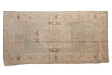 Distressed Oushak runner with faded cameo medallion in soft sea foam green and pale rose. 3'2