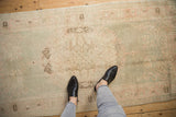 Distressed vintage Oushak runner with faded seafoam green, rose, and ivory curvilinear motifs.