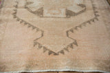 Distressed vintage Kurd rug pile showcasing worn texture and visible foundation in beige and charcoal.