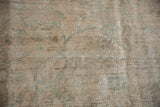 The low, worn pile and hand-knotted texture of a vintage distressed Oushak carpet.