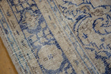 Distressed texture of Oushak rug, deep cobalt blue pattern over pale sandalwood foundation.