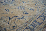 Distressed Oushak rug's worn pile, exposed foundation, and faded blue palmette details.