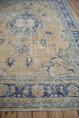 Distressed Oushak carpet with worn gold pile and blue curvilinear palmette patterns.