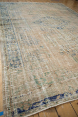 Decorative distressed Oushak carpet texture with faded blue, green, and beige patterns.