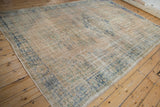 Vintage Distressed Oushak rug corner showing worn beige foundation, faded blue and green patterns.