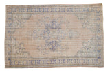 Vintage distressed Oushak carpet with a central medallion and palmette border in soft blue and ivory tones.