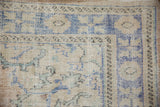 Hand-knotted texture and wear on the pale blue and seafoam palmette border.
