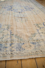 Textured low pile of a vintage distressed Oushak showing decorative wear.