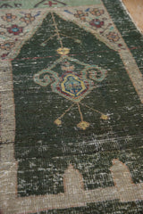 Distressed dusty charcoal teal Oushak rug with central ornamented lantern and visible knot wear.