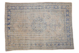 Faded cream and pale cobalt blue distressed Oushak rug with central medallion pattern.