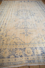 Distressed Oushak carpet detail, showing worn pile, foundation, and faded blue vinery on cream.