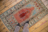 Vintage distressed Anatolian rug, exhibiting its faded red prayer design and intricate Ladik-style borders.