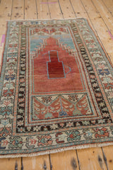 Distressed Anatolian rug's lower panel with pale raspberry, aqua, jade floral motifs.