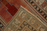 Distressed Anatolian rug corner: raspberry red field, aqua zig-zag, varied Ladik motifs.