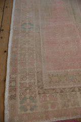 Close view of the time-softened floral border and intact side cord on a vintage Oushak rug.