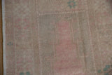 Detail of the distressed texture and intact side cord on a vintage Turkish Oushak rug.