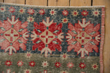 Distressed Oushak rug detail: rose quatrefoil, dusty denim blue, slate green.