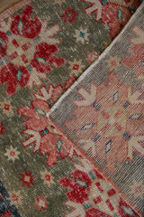 Distressed red and green Oushak pile with quatrefoil motifs and hand-knotted reverse.