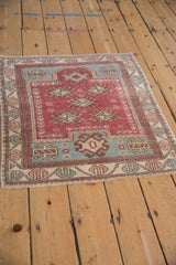 High-angle view of a vintage square Oushak rug with a distressed, low-pile texture.