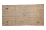 Distressed Oushak runner rug with faded cobalt blue central medallion and geometric corners.