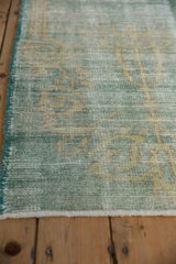Distressed vintage Oushak rug pile revealing worn foundation and mint green shades.