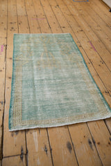 Distressed Oushak rug corner highlighting even textural wear and pale mint green hues.