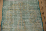 Distressed vintage Oushak rug detail, showing wear to foundation, faded mint green, and beige.