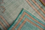 View of the striped back and secured side cord on a hand-knotted vintage Oushak rug.