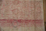Textured beige pile of vintage Oushak rug showing red weft abrash.