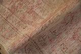 Distressed vintage Oushak rug runner pile showing visible red abrash and textured beige tones.