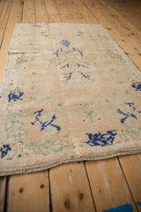 Faded cobalt blue patterns and low pile texture on a distressed vintage Oushak rug.