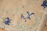 Distressed vintage Oushak rug with cream, cobalt blue, sea foam green, and significant abrashes.