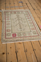 Distressed geometric serrated flowers in raspberry red with softened silver tones on this vintage Oushak.