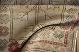 Distressed vintage Oushak rug with time-softened pile, raspberry red serrated flowers and geometric border.