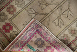 Distressed Oushak rug's time-softened front pile and vibrant patterned hand-knotted reverse.