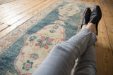 Scalloped ivory medallion over abrashed dusty aqua teal on a distressed Oushak runner.